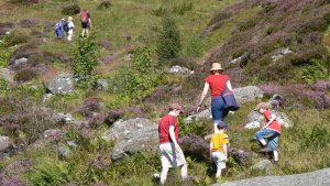 famiglia che si arrampica sui massi durante l'escursione