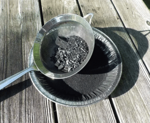 Screening-The-Charcoal-Through-A-Strainer